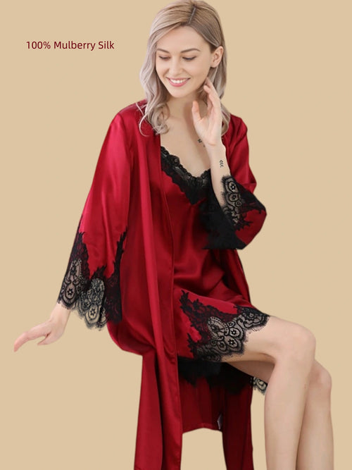 Seated view of a Deep Red 16 Momme mulberry silk robe with black lace cuffs and a matching slip dress