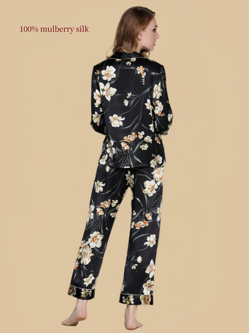 Back view of Silkgala black floral mulberry silk pajama set featuring botanical blossoms across the long-sleeve shirt and matching pants.