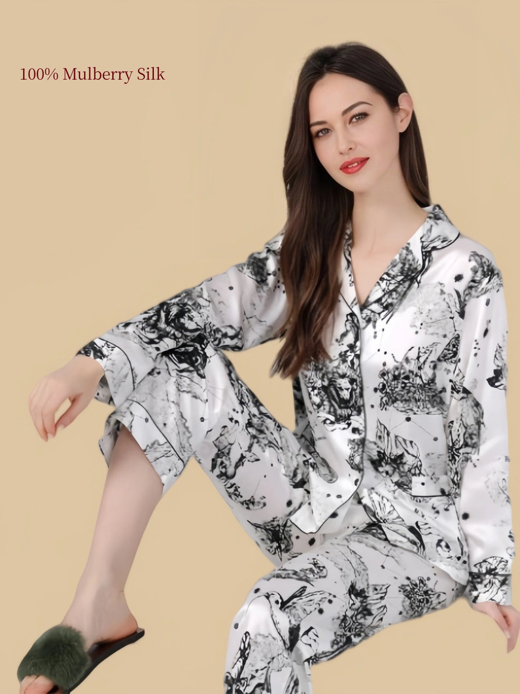 Model wearing Silkgala black-and-white ink-wash silk pajamas in a seated pose, showing the relaxed fit and fluid drape of the matching set.