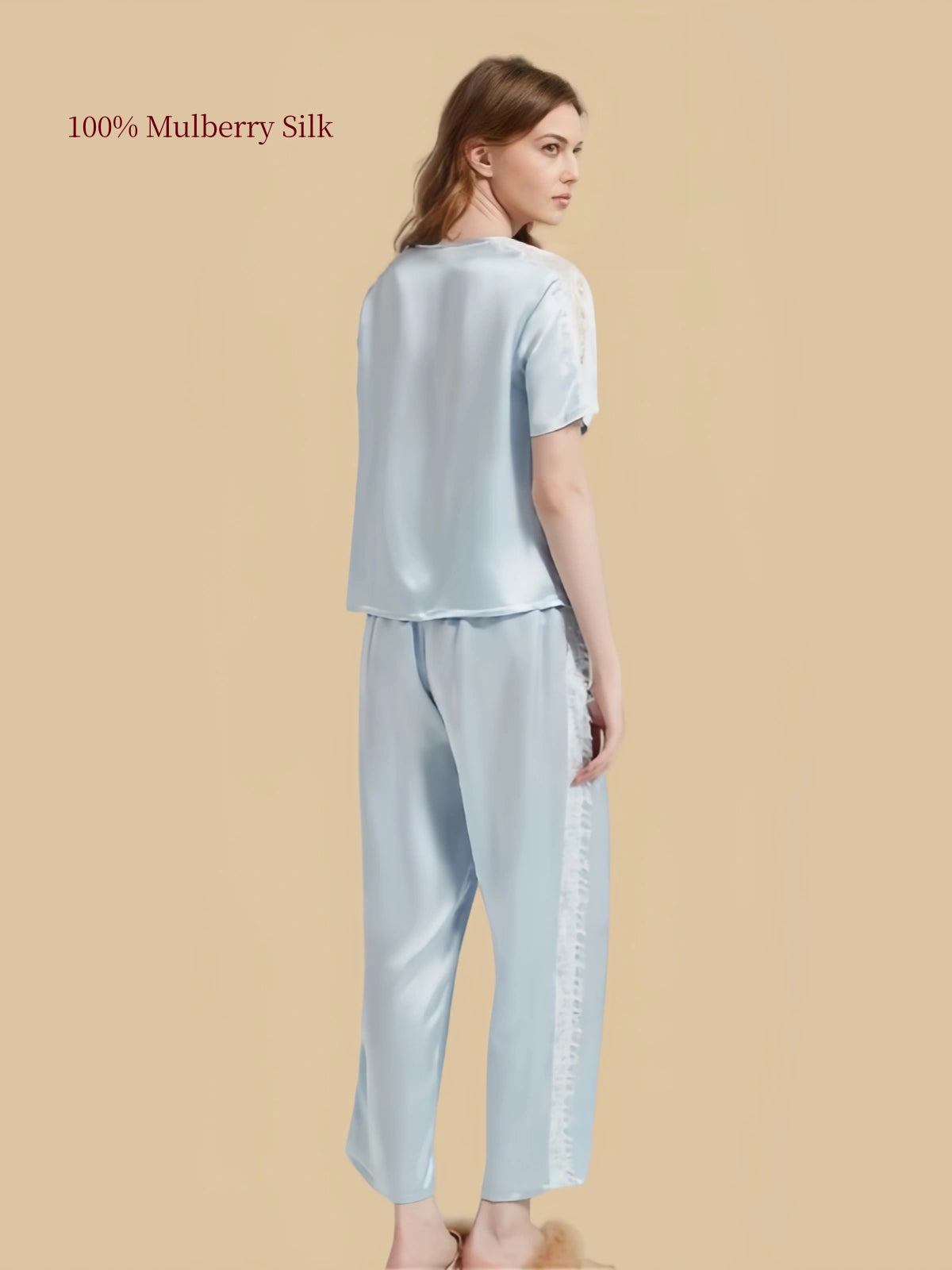 Back three-quarter view of Aqua Blue silk pajamas showing relaxed pullover top and lace detailing along outer pant legs