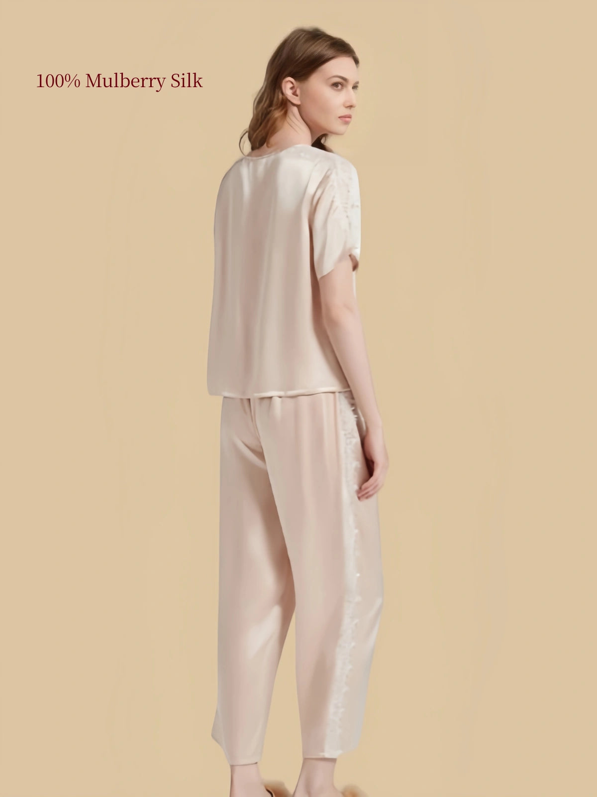 Back three-quarter view of Light Apricot silk pajama set highlighting smooth silk fabric and outer leg lace inserts