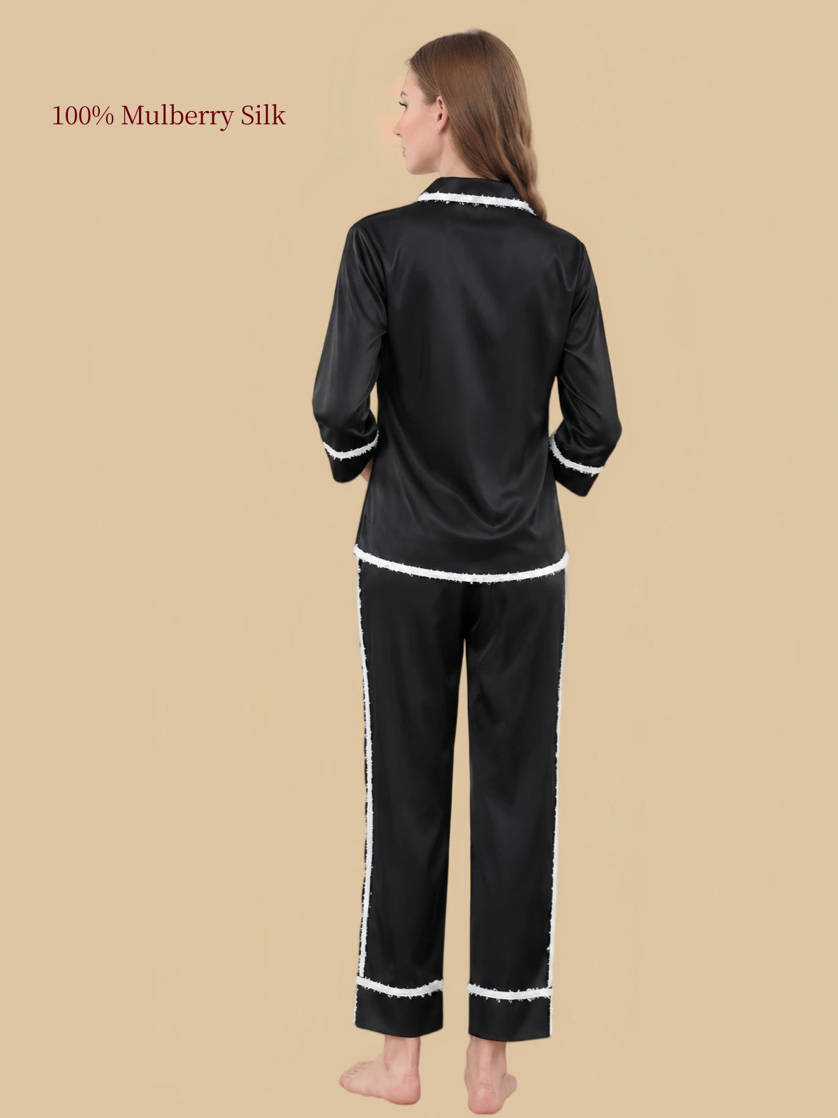 Back view of the Black mulberry silk sleepwear set with white contrast trim along the cuffs and pant seams.