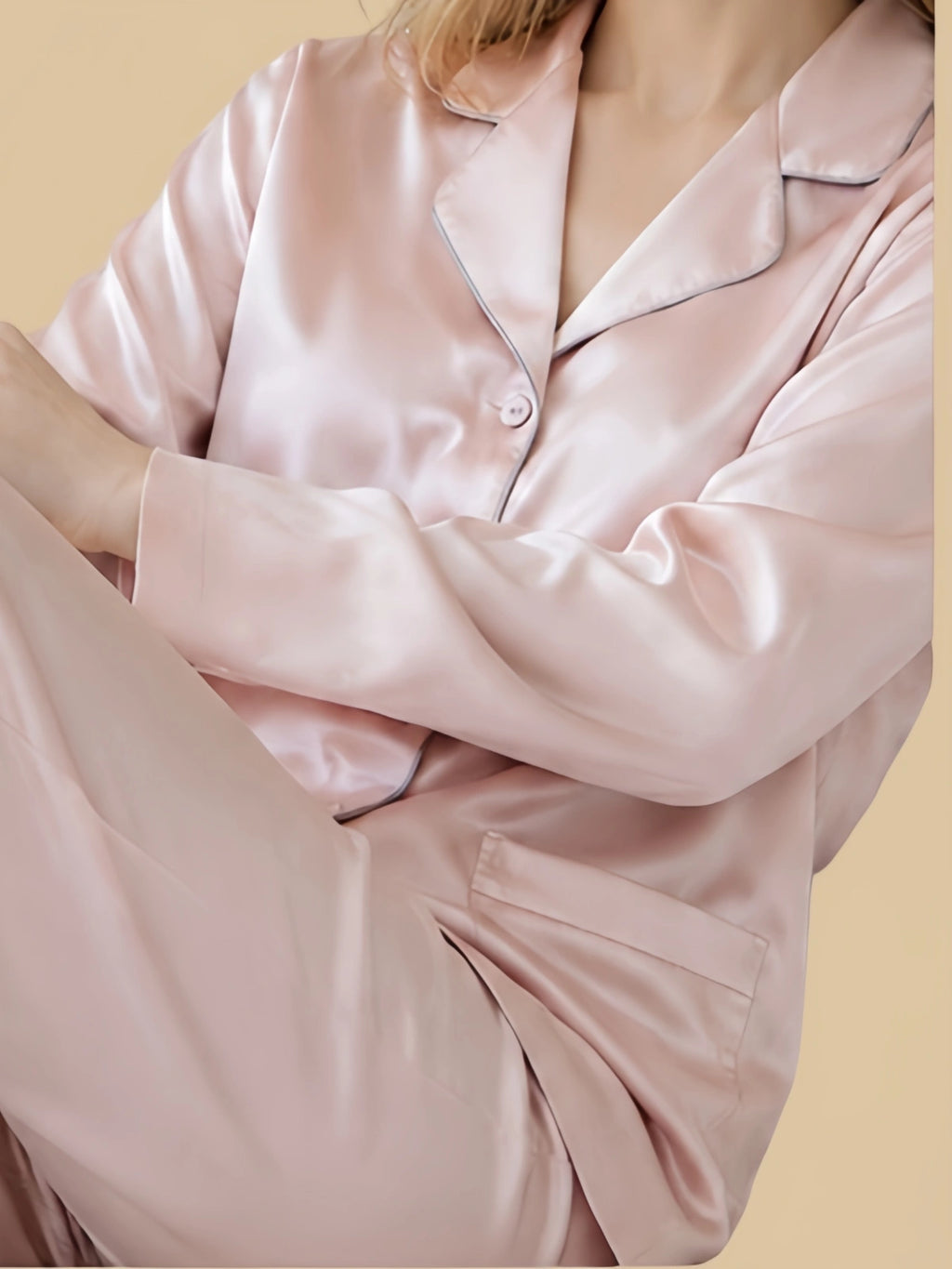 Close-up of Pale Lotus-Root Pink mulberry silk pajama top showing contrast piping along the notched lapels and wide cuffs
