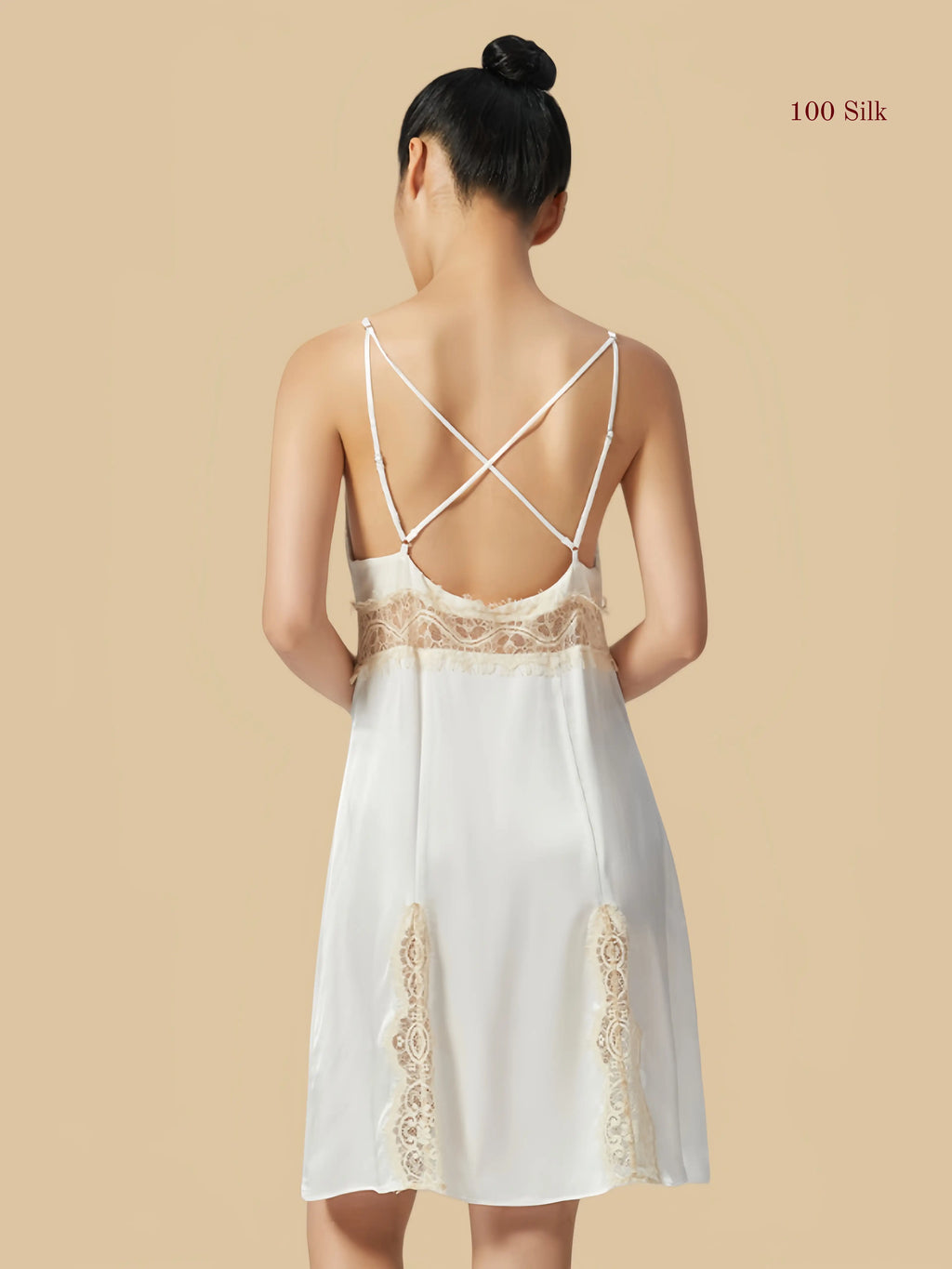 Back view of a white silk dress showcasing a deep open back design with elegant cross-over adjustable straps.