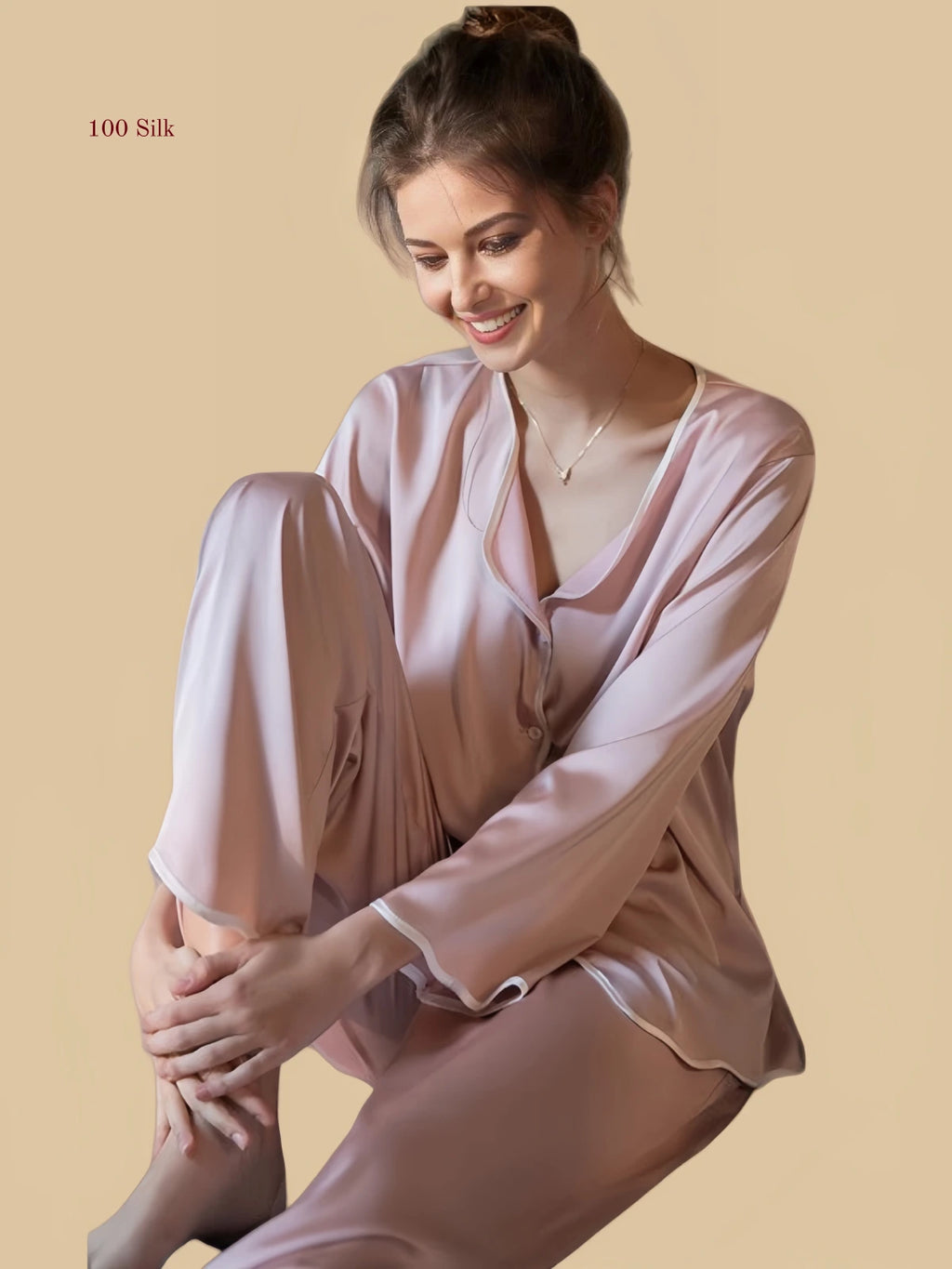 Pink 19mm soft-neck silk set seated view with fluid long-sleeve top and full-length pants