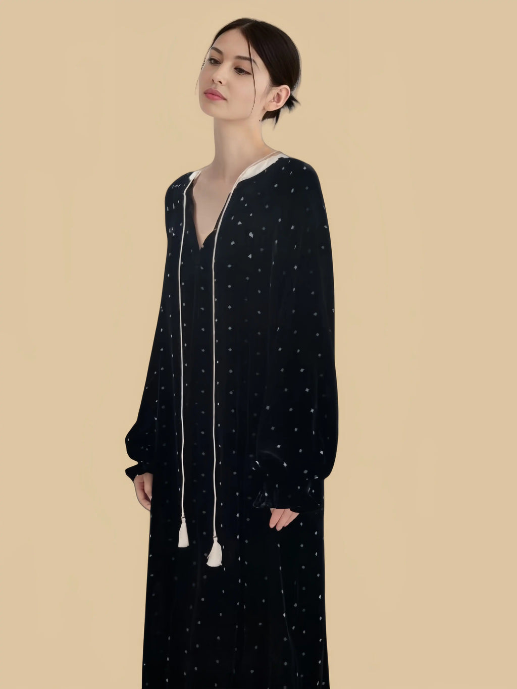 Black tassel-tie velvet dress front three-quarter view with split neckline and tassel ties