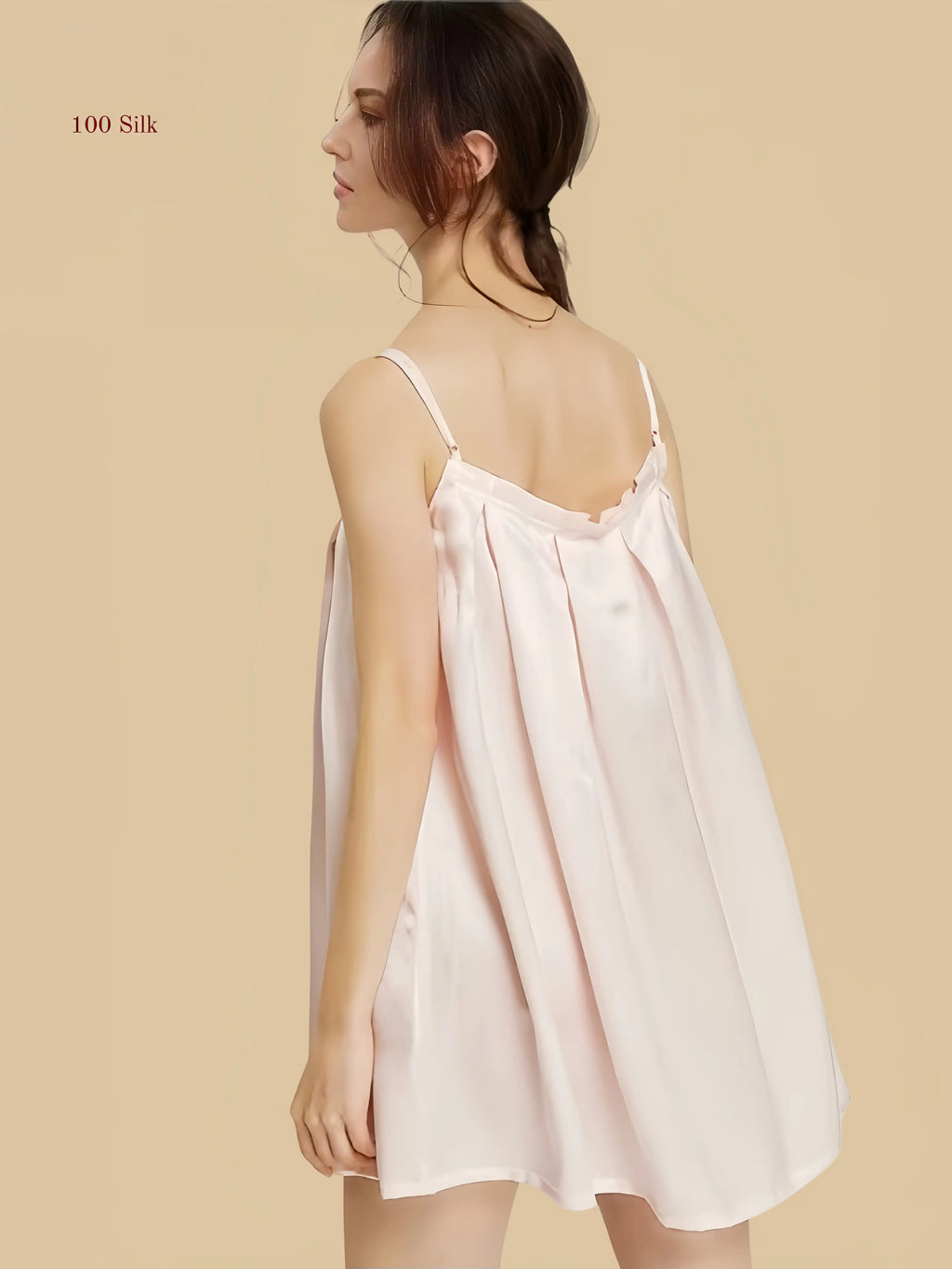 Back view of a misty Light pink silk pleated nightgown showcasing a relaxed fit and adjustable spaghetti straps.