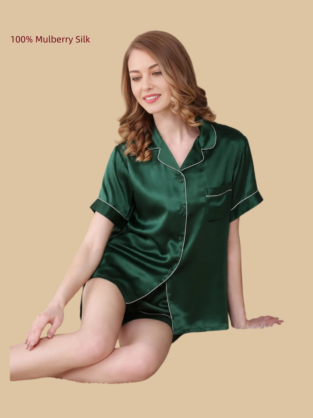 Woman seated in a green mulberry silk short pajama set with contrast piping