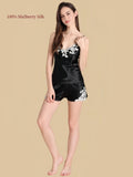 Woman wearing a black 19 Momme mulberry silk camisole and shorts set with contrasting floral embroidery