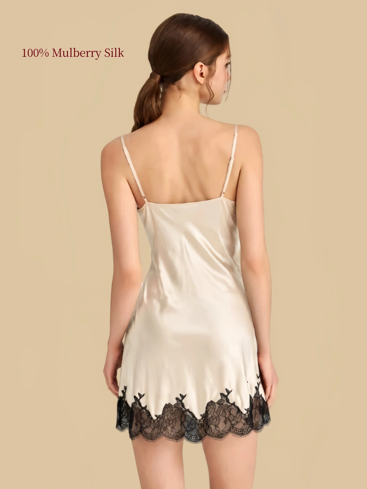 Back view of a Cream White silk slip nightdress with adjustable straight shoulder straps and black floral lace along the hem.