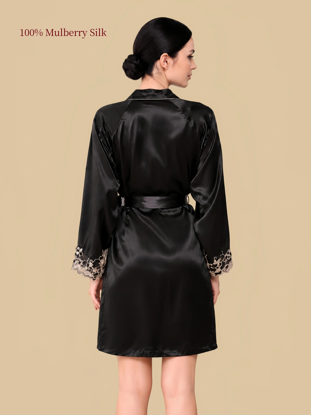 Back view of a black silk robe with a tied waist belt, smooth silk finish and floral lace sleeve cuffs.