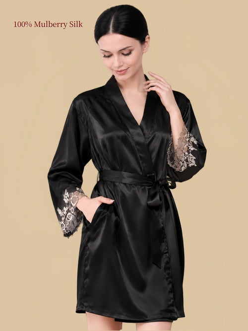 Front view of a black mulberry silk wrap robe with floral lace cuffs, waist belt and side pockets.